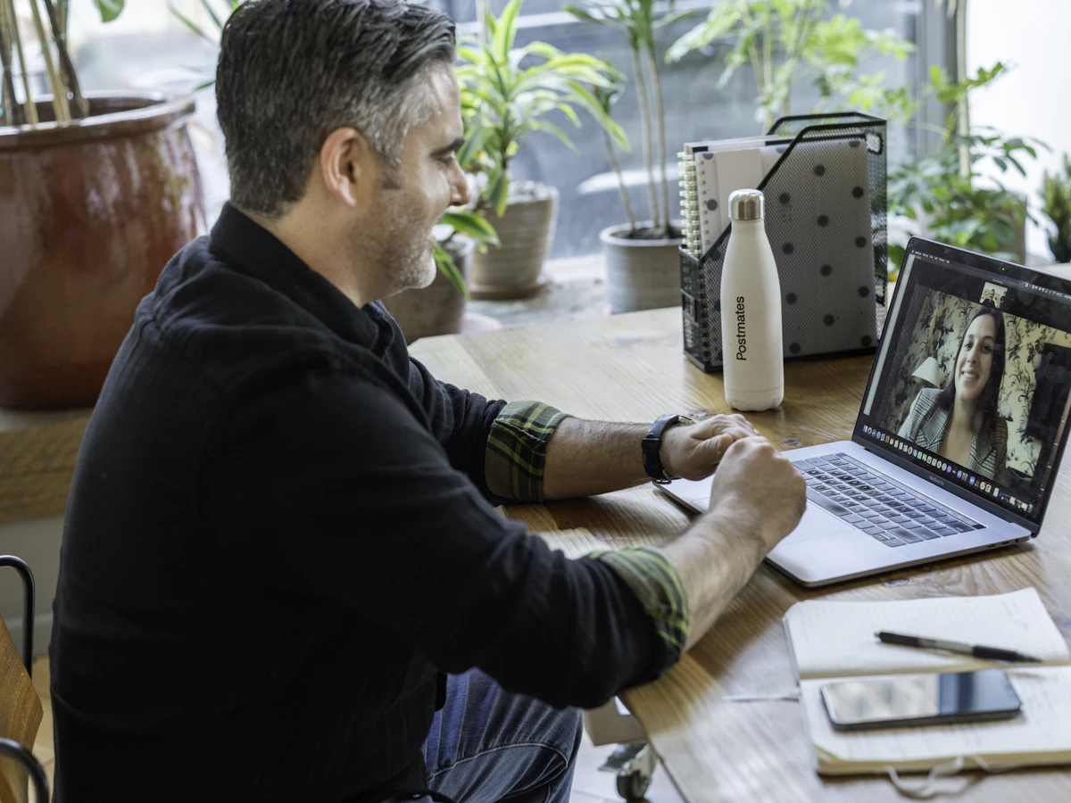 Man smiling on a video call with a colleague on his laptop